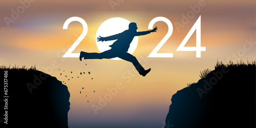 Un homme saute par dessus un gouffre entre deux falaises devant un soleil au zénith et symbolise le passage à la nouvelle année 2024. photo