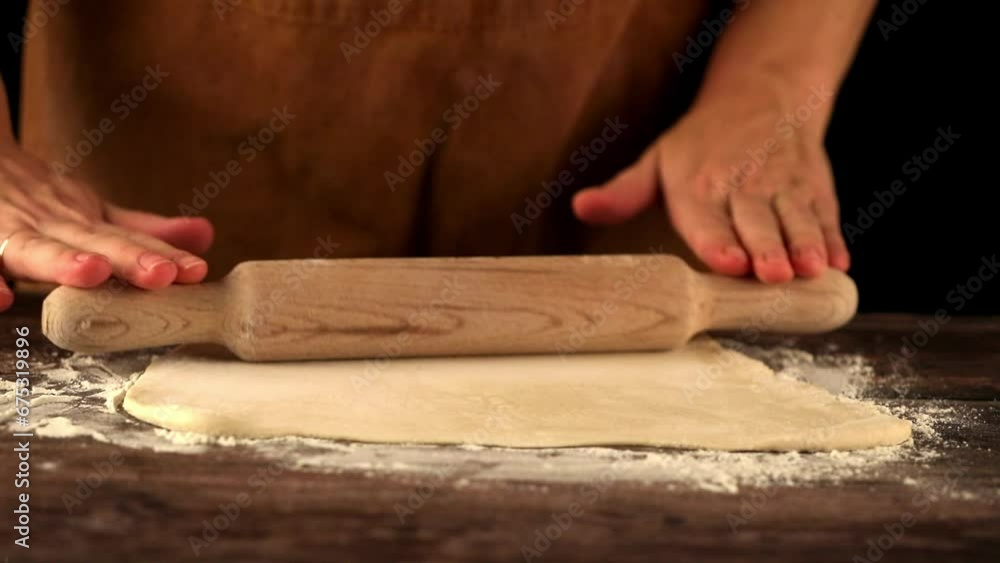 Female hands rolling out dough with a rolling pin Female hands rolling out dough with a rolling pin