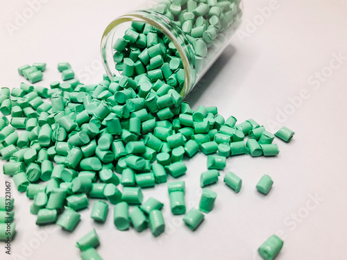 Mint green masterbatch granules with glass tube isolated on white background, this polymer is a colorant for products in the plastics industry