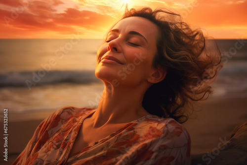 Middleaged woman resting with her eyes closed on a beach at sunset. Concept of peace and tranquility.
