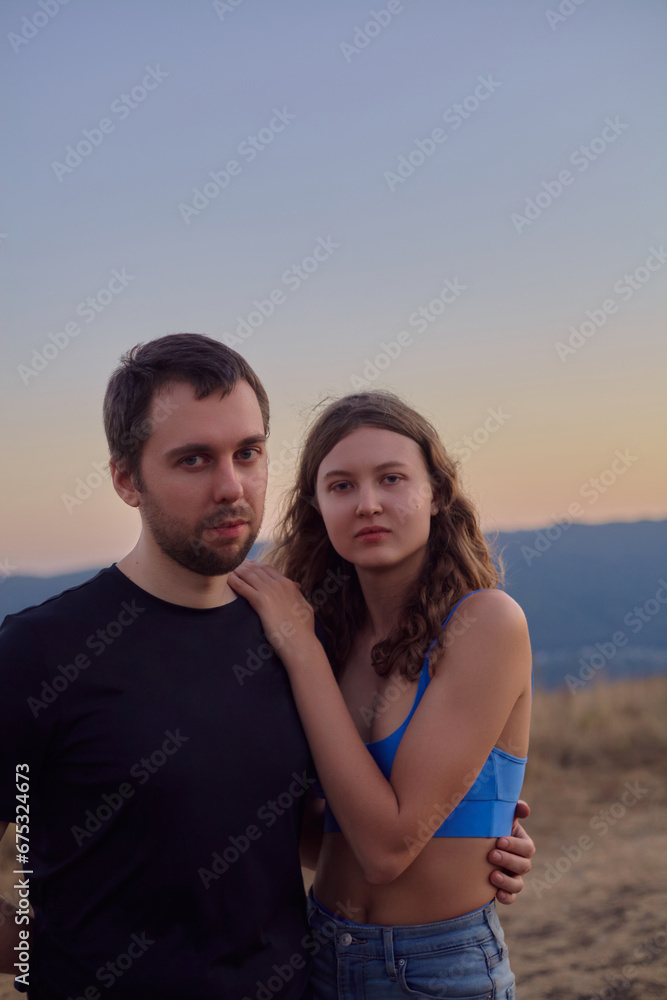 portrait of a happy couple in the mountains against the sunset