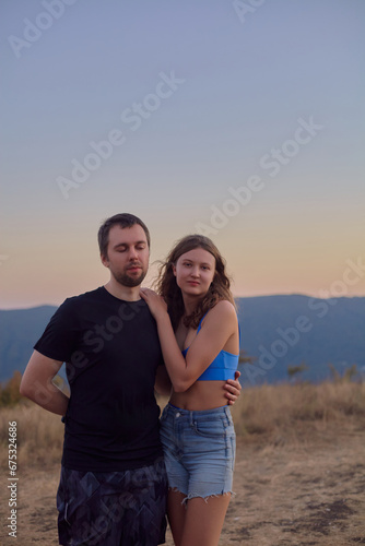 portrait of a happy couple in the mountains against the sunset
