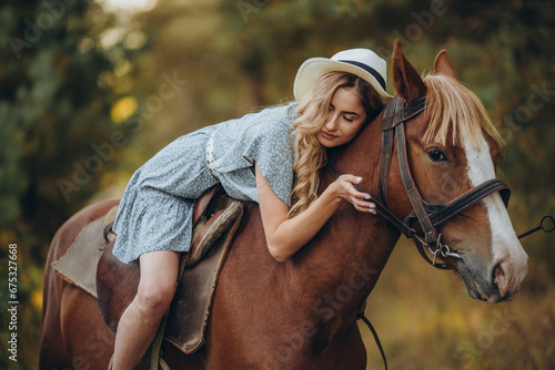 A young beautiful woman rides a horse in the forest in autumn. Horseback riding in the evening in autumn.