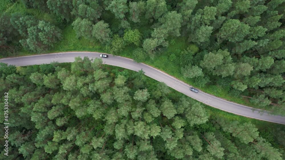 Aerial View Black Car Driving Down an Asphalt Road Crossing Vast Forest on Summer Day. Aerial Shot of Car Driving on Road in Pine Tree Forest. Road Trip Through Forest. Scenic Summer Landscape. Aerial View Black Car Driving Down an Asphalt Road Crossing Vast Forest on Summer Day. Aerial Shot of Car Driving on Road in Pine Tree Forest. Road Trip Through Forest. Scenic Summer Landscape.