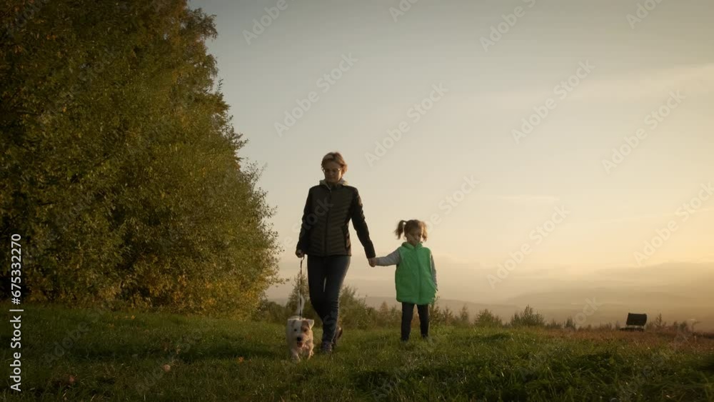 Woman with little daughter walking the dog in the park forest. travel concept. wide Slow motion footage Woman with little daughter walking the dog in the park forest. travel concept. wide Slow motion footage