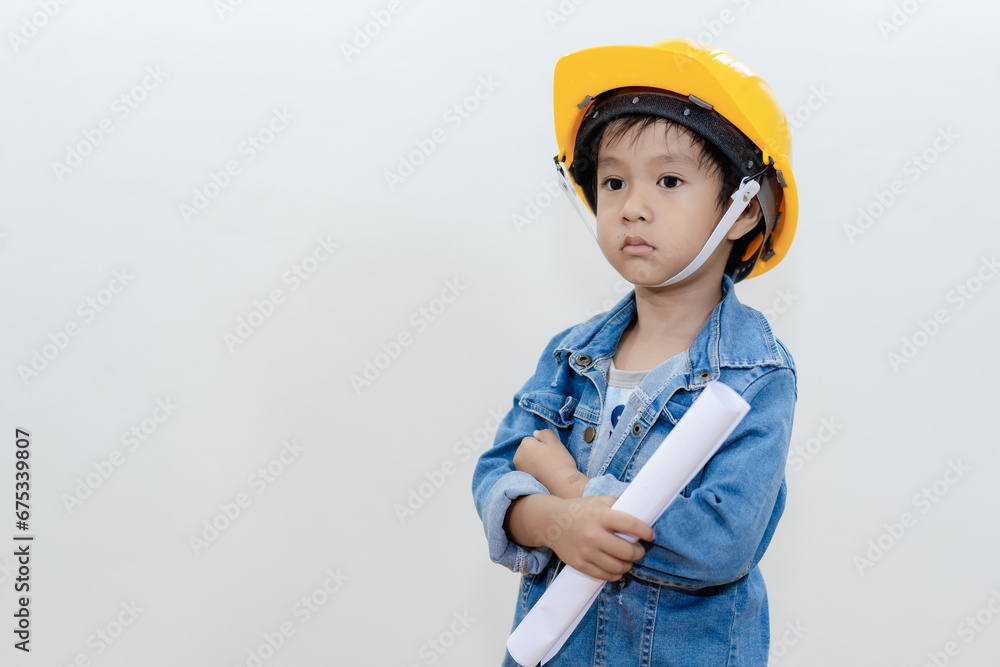 Cute Asian thai happy kid wearing yellow construction helmet or safety hard hat, standing isolated on white background..