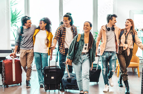Young group of tourists with suitcases arriving at youth hostel guest house - Happy friends enjoying summer vacation together - Millenial people doing check-in at hotel lobby - Summertime holidays photo
