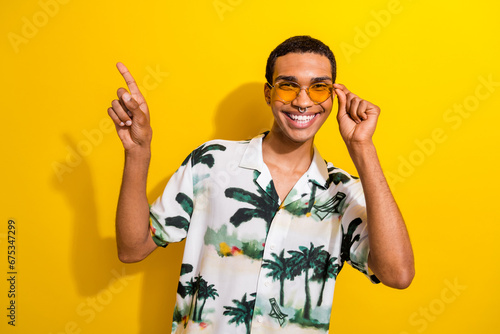 Photo of attractive nice hipster man dressed trendy clothes arms direct empty space proposition offer isolated on yellow color background