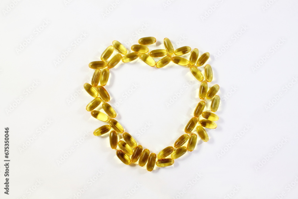 heart shape fish oil or linseed oil vitamin pills,gelatin capsule or tablet for health,heart health,medical,ayurvedic,phrmacy,naturopathy related concept in white background,top view,copy space heart shape fish oil or linseed oil vitamin pills,gelatin capsule or tablet for health,heart health,medical,ayurvedic,phrmacy,naturopathy related concept in white background,top view,copy space
