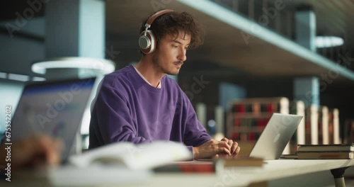 Close Up Footage of a Person Writing in Notebook. Focus Switching to a Thoughtful College Student Using Laptop Computer for Studying in a Library. Handsome Man Learning Online, Getting Ready for Exams photo