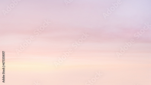Colorful sky with soft and blur pink, purple, yellow pastel colored clouds. Copy space wallpaper.
