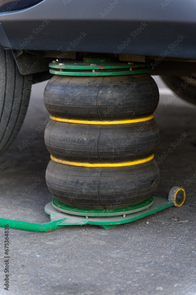 A pneumatic jack supports the vehicle while changing tires. A pneumatic jack supports the vehicle while changing tires.