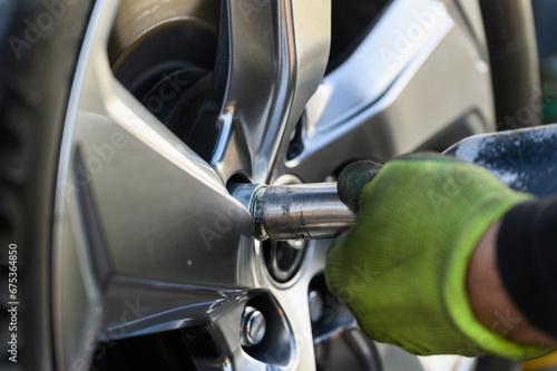 Wallpaper Mural Car mechanic changing wheels in car Torontodigital.ca