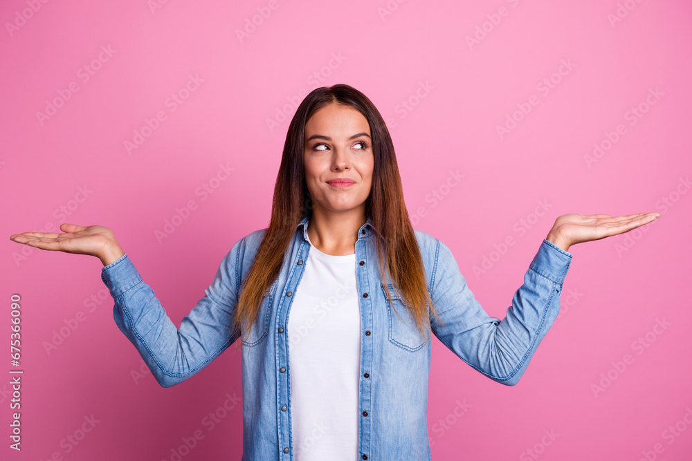Portrait of nice curious cheery brown-haired girl holding on palms copy space choosing options isolated over pastel color background - obrazy, fototapety, plakaty 