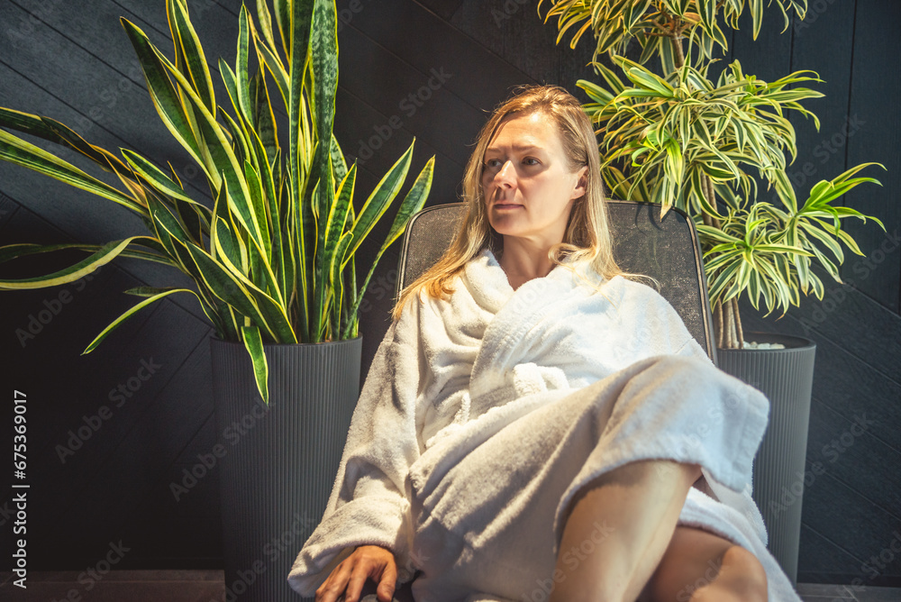 Woman in white bathrobe lying on sofa and relaxing at SPA. - obrazy, fototapety, plakaty 
