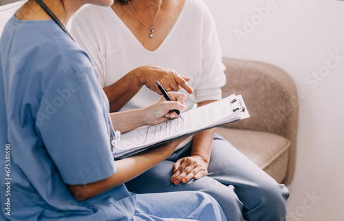 Doctor showing medical card to patient at table in clinic  closeup