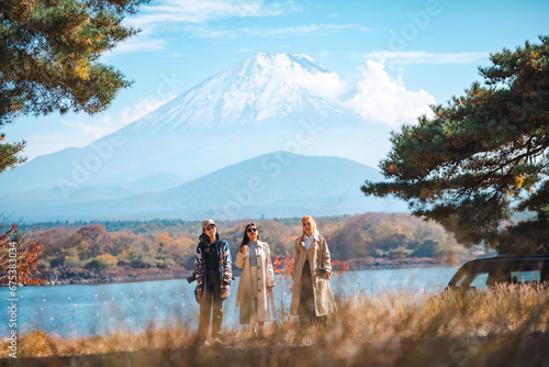 Attractive girl friends happy and fun together while travel Mt.Fuji landscape view and looking beautiful red maple tree leaf falling in autumn, Happy Asian woman travel in Japan on holiday vacation