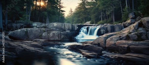 In the tranquil Adirondack Park the flowing water of the river gracefully cascades down the rocks creating a breathtaking natural waterfall amidst the stunning landscape while the gentle mo photo