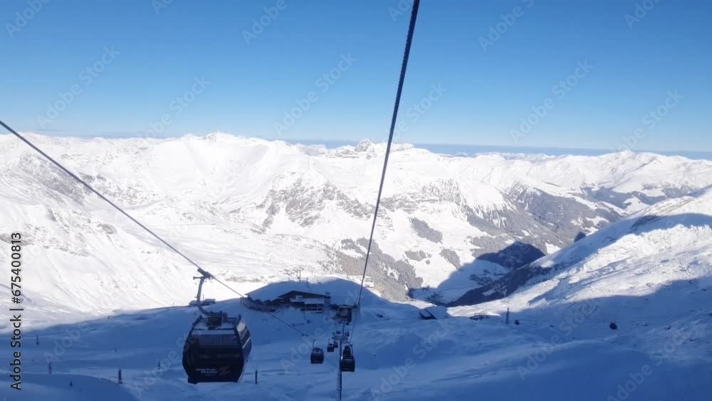Cable car ride on Winter ski resort in the Austrian Alps. Hintertuxer glacier. Winter scenery of sun, snow and skiers. Cable car ride on Winter ski resort in the Austrian Alps. Hintertuxer glacier. Winter scenery of sun, snow and skiers.