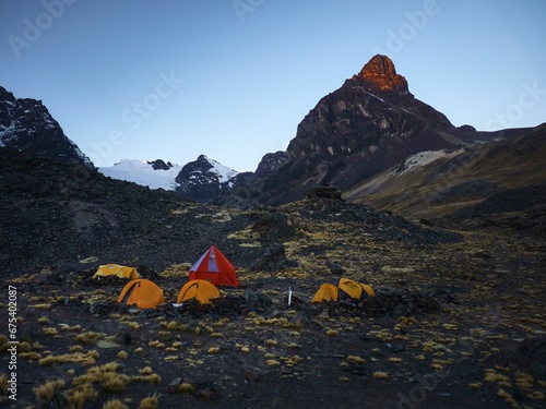 Nighttime scene featuring several camping tents in front of mountain landscape in Condoriri Bolivia photo