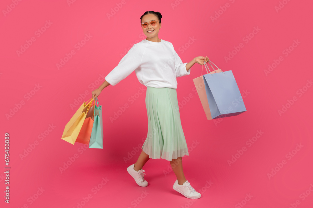 Shopping Concept. Happy Beautiful Asian Woman Walking With Bright Shopper Bags Shopping Concept. Happy Beautiful Asian Woman Walking With Bright Shopper Bags