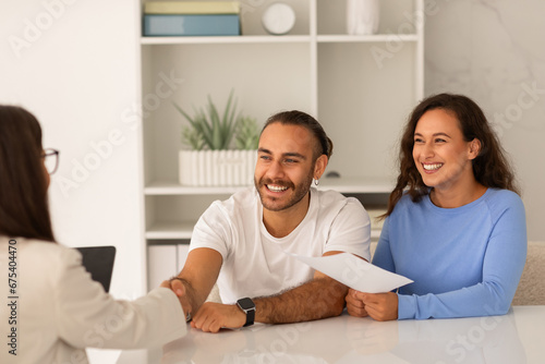 Young couple visiting doctor, shaking hand, happy with results