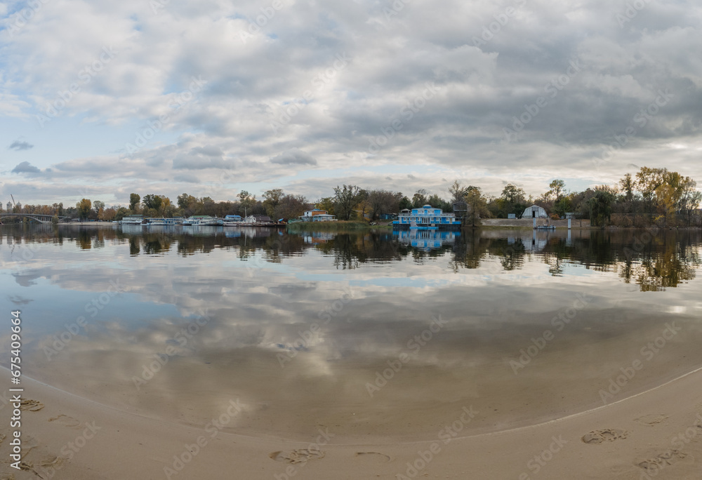 Beautiful autumn landscape of a beach near a river with a view of the opposite bank