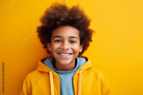 happy african american child boy takes a selfie on a smartphone against the background of a yellow room