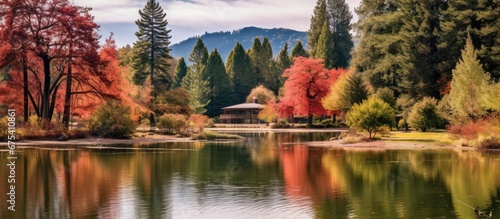In the tranquil autumn park the beautiful landscape captured my attention with its lush green forests majestic mountains and vibrant colors of red orange and yellow all under the clear blue  © TheWaterMeloonProjec