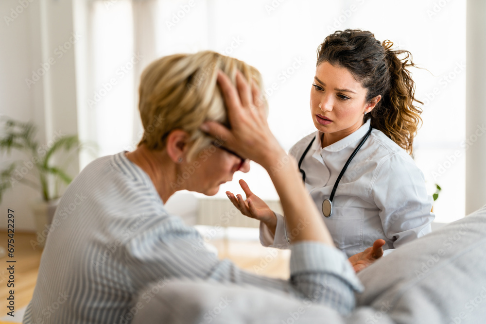 Young concerned female medical practitioner reassuring worried patient that everything is going to be okay. Sad woman patient with female doctor. Young concerned female medical practitioner reassuring worried patient that everything is going to be okay. Sad woman patient with female doctor.