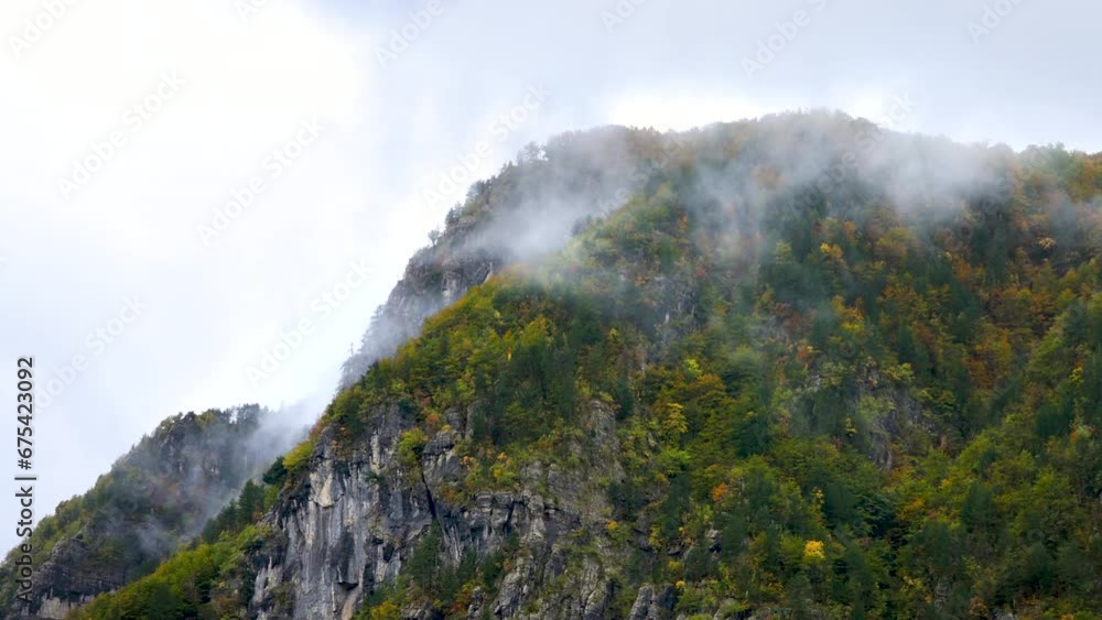 Clouds passing over an autumn colored mountain ridge in the Albanian Alps Clouds passing over an autumn colored mountain ridge in the Albanian Alps