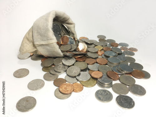 coins spilling out of a bag Coins in a bag With a white background photo