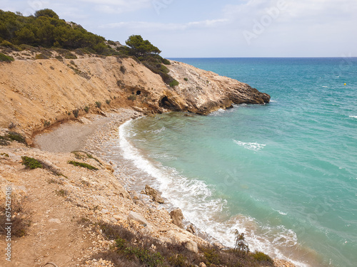 Rocky sandy beach, coastline with turquoise sea, wave splash, Catalonia, Spain