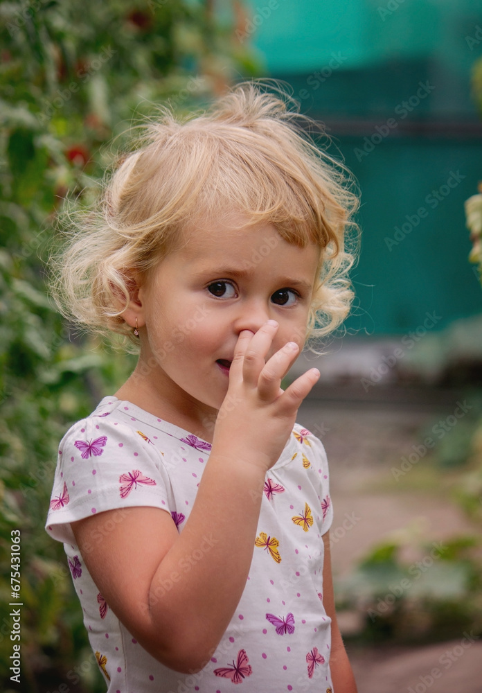 A beautiful girl looks at the camera and picks her nose. A beautiful girl looks at the camera and picks her nose.
