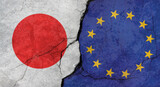 Japan and European Union flags, concrete wall texture with cracks, grunge background, military conflict concept