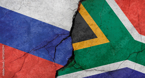 Russia and South Africa flags, concrete wall texture with cracks, grunge background, military conflict concept