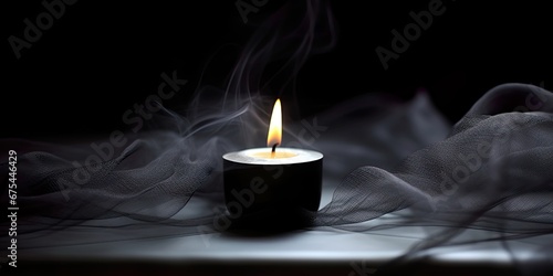 Condolence, grieving card, loss, remembrance. Candle on a dark table burning, symbole of mourning of a loved one. Black net fabric and dark background. Card for words of support and comfort.  photo