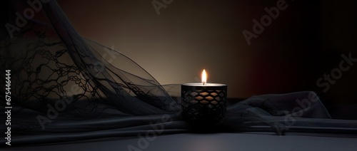 Condolence, grieving card, loss, remembrance. Candle on a dark table burning, symbole of mourning of a loved one. Black net fabric and dark background. Card for words of support and comfort.  photo