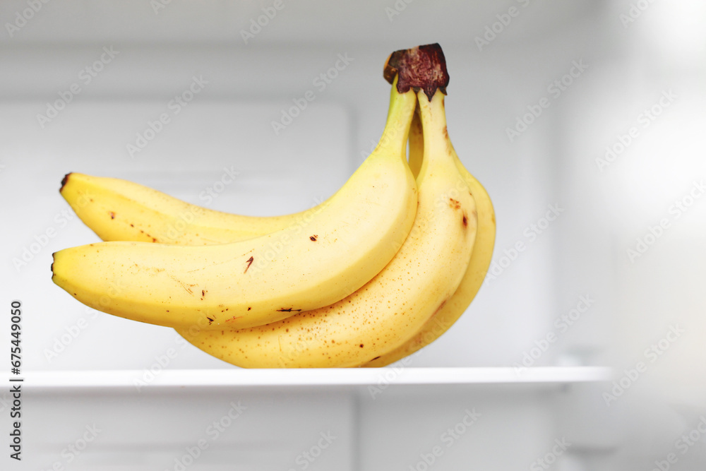 Bananas in fridge. Isolated on white fridge door. Yellow fruit with