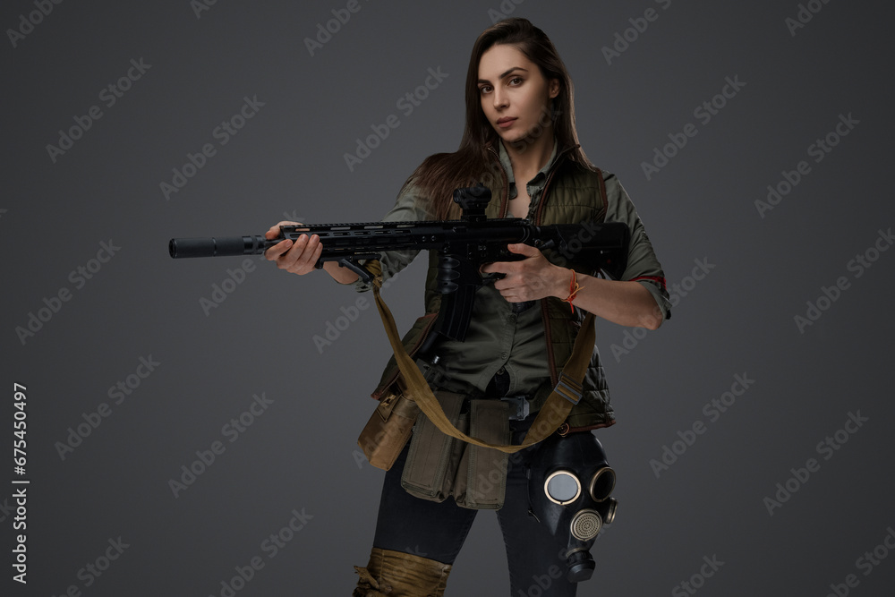Middle Eastern-looking woman dressed in survivalist clothing posing with a rifle against a gray background, portraying strength and resilience Middle Eastern-looking woman dressed in survivalist clothing posing with a rifle against a gray background, portraying strength and resilience