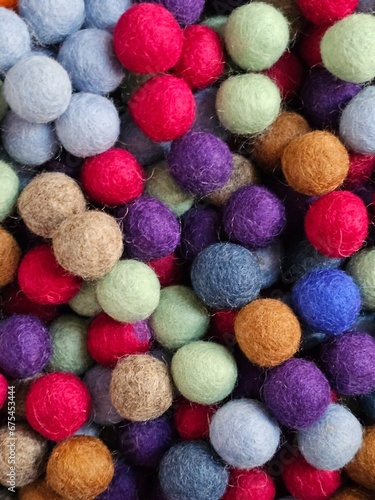 A vibrant heap of variously hued woolen balls  creating a vivid mosaic of colors just waiting to be crafted.