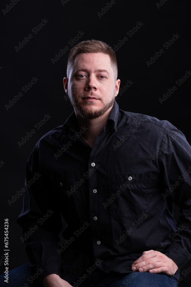 Strict and stylish Man in black shirt on dark background. Strict and stylish Man in black shirt on dark background.