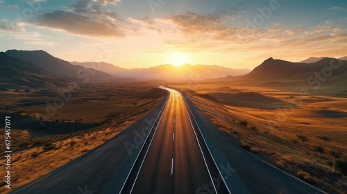 Scenic curved highway asphalt road with golden sky and mountain in the sunset photo