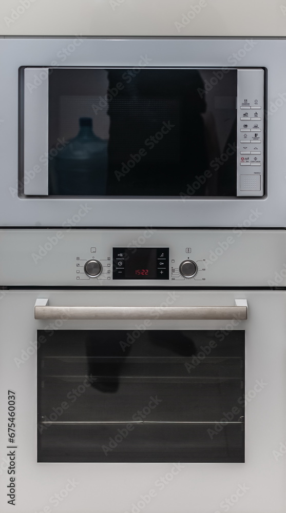 Obraz premium Built-in cabinet microwave and electric oven close-up