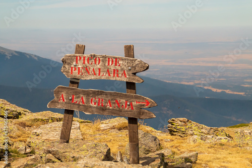 Cartel de madera direccional en el sendero, hacia el pico de Peñalara o La Granja en Segovia, Sierra de Guadarrama, Madrid, España.