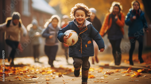 Photo of a smiling child at a school stadium playing football with other children.