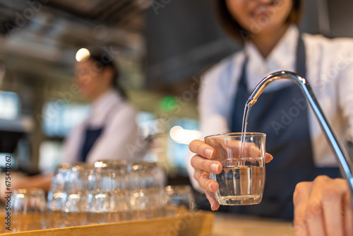 Girl in apron cleaning a cup and looking contented photo