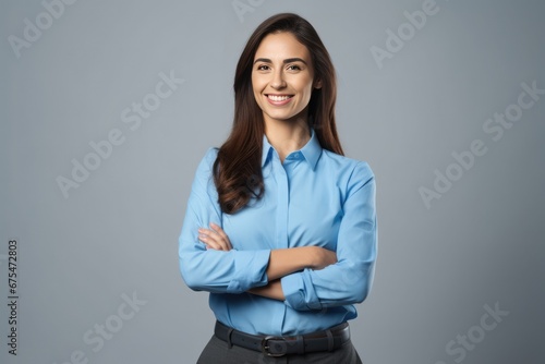 Happy young smiling confident professional business woman wearing blue shirt, pretty stylish female executive looking at camera, standing arms crossed isolated on gray background photo