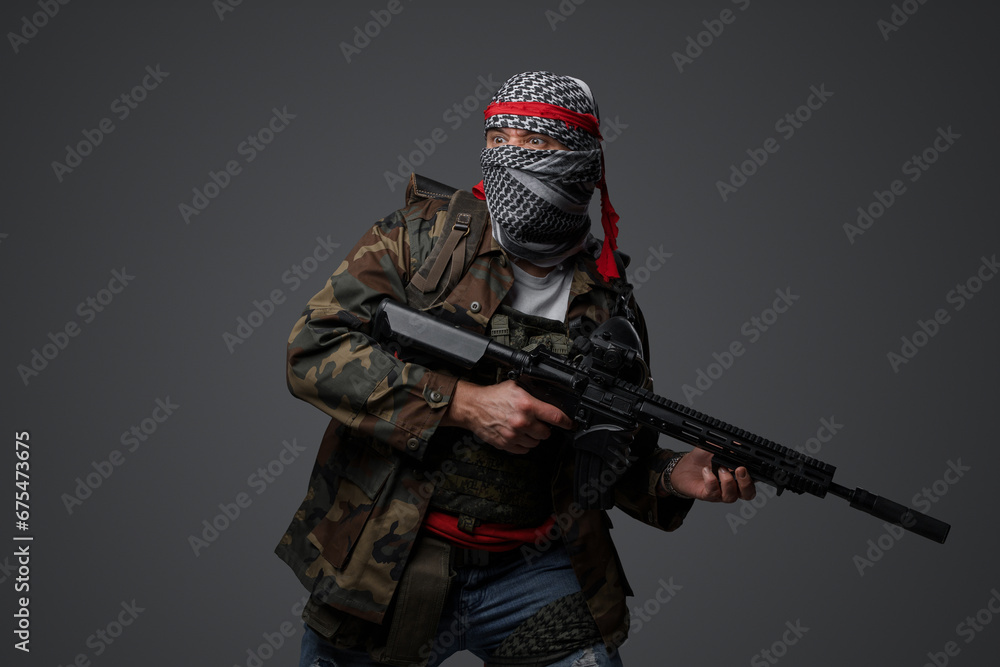 Militant from the Middle East, dressed in a white keffiyeh and camouflaged field attire, wielding an automatic rifle, set against a neutral gray backdrop Militant from the Middle East, dressed in a white keffiyeh and camouflaged field attire, wielding an automatic rifle, set against a neutral gray backdrop