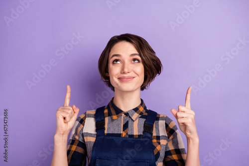 Photo of young woman craftsman happy smile look indicate fingers up advert choose select isolated over purple color background